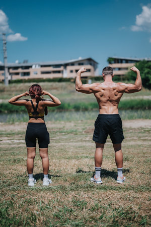 Back view of athletic people flexing muscles outdoors on a sunny dayの写真素材