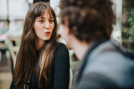 Two friends engaging in a lively conversation outdoorsの写真素材