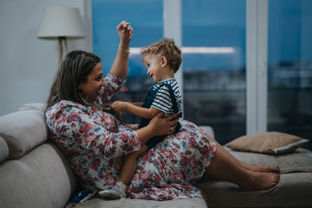 Mother and child play on a sofa at home, joyful bonding momentの写真素材