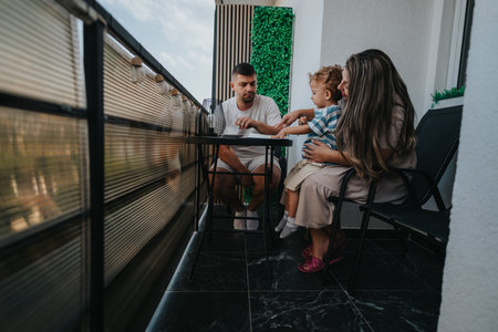 Family on a balcony enjoying outdoor dining together at a modern home terraceの写真素材