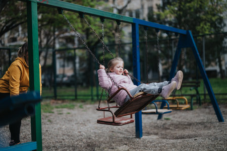 Young girl enjoying a swing ride at a sunny park