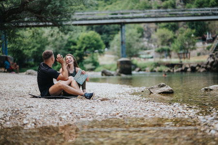 Two friends enjoying a riverside outing in beautiful natural surroundingsの写真素材