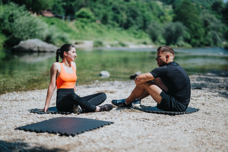 Two individuals enjoying an outdoor yoga session by a scenic riverの写真素材