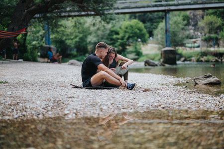 Couple enjoying a relaxing day near a river with a mapの写真素材