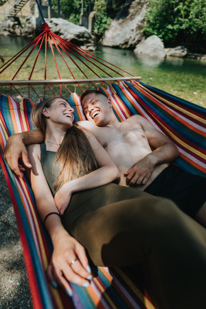 Couple relaxing in a hammock by the river on a sunny dayの写真素材