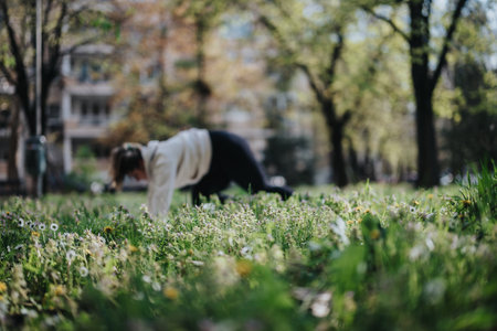Person practicing fitness outdoors on a grassy field surrounded by natureの写真素材