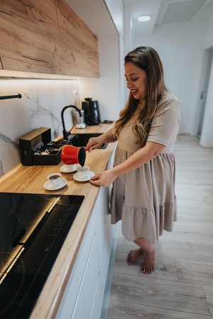 Woman pours coffee for two in a modern kitchen during a cozy morning ritualの写真素材