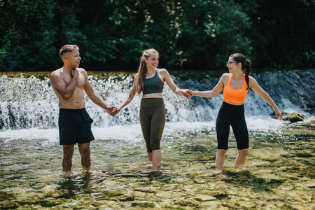 Group of friends enjoying a fun day by a serene river outdoorsの写真素材