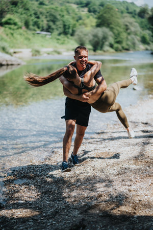 Couple Enjoying a Fun Outdoor Moment by a Scenic Riverの写真素材