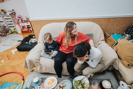 Women Sitting on Sofa Enjoying Time with Friends and Family in Cozy Homeの写真素材