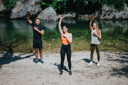 Group of people exercising by a serene river in outdoor settingの写真素材