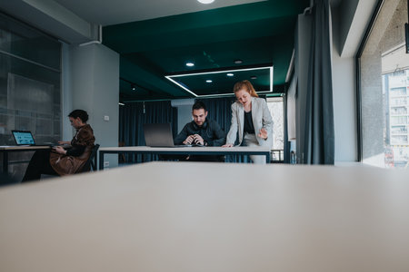 Collaborative business meeting with three colleagues working in a modern officeの写真素材