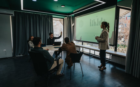 Team members discussing a business presentation in a modern office settingの写真素材