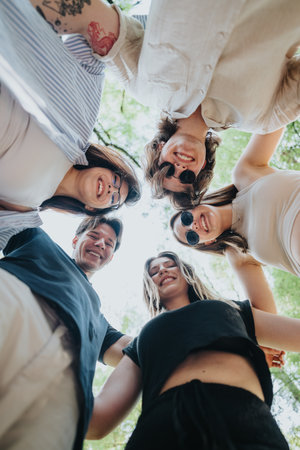 Group of friends bonding together in a circle outdoors on a sunny day