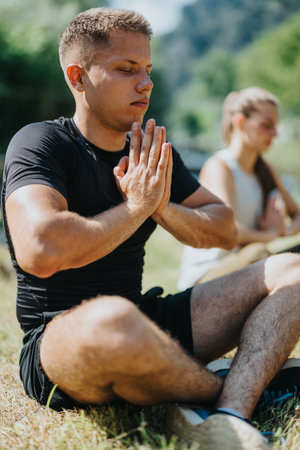 Man practicing yoga in a serene outdoor setting near a calm riverの写真素材