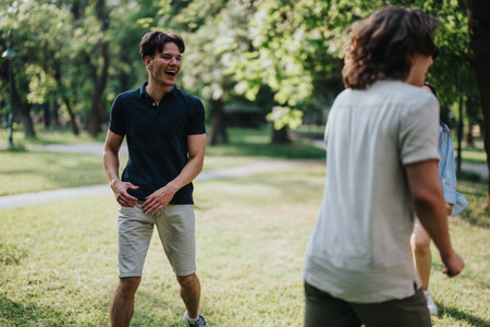 Young friends enjoying a sunny day while laughing together in a green parkの写真素材