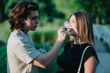 Young couple sharing a tender moment in a sunny park settingの写真素材