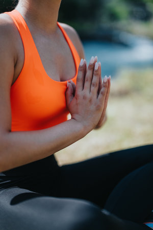 Close-Up of Woman Practicing Yoga In Nature Near Tranquil Riverの写真素材