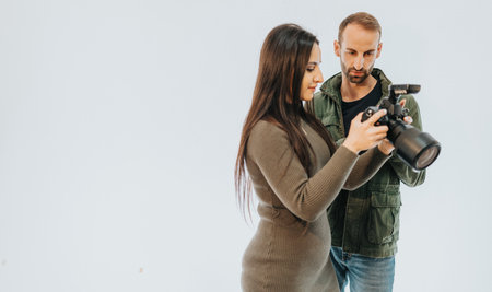 Photographer Discussing Camera Technique with a Colleague in a Studio Settingの写真素材