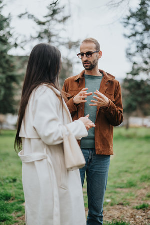 Two individuals having a conversation outdoors in a natural settingの写真素材