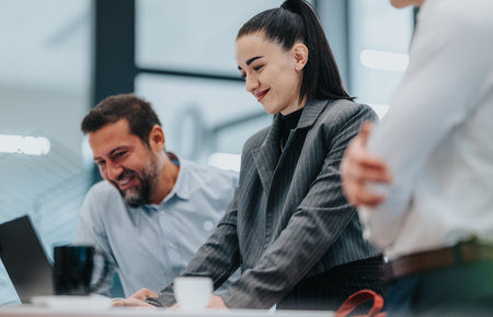 Professional team collaborates in a modern office, sharing ideas and planning a project togetherの写真素材