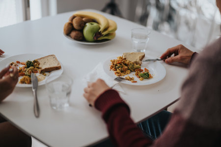 Two people enjoying a healthy breakfast with bread and vegetables at home