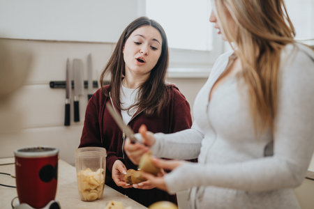 Two women preparing food together in a modern kitchenの写真素材
