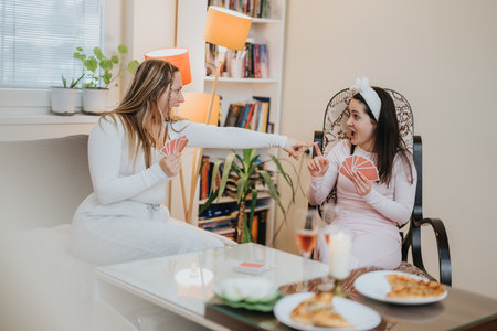 Two friends playing cards and sharing laughter at a cozy indoor gathering