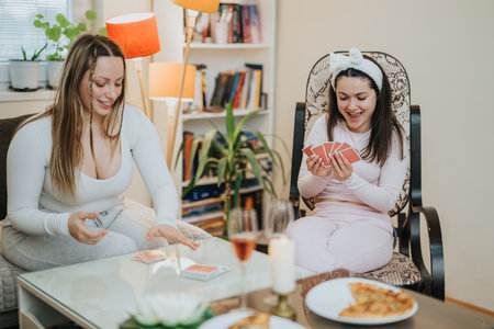 Two friends enjoying a card game together in a cozy living roomの写真素材