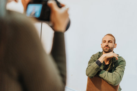 Man sitting on chair during a photo shoot captured in natural lighting