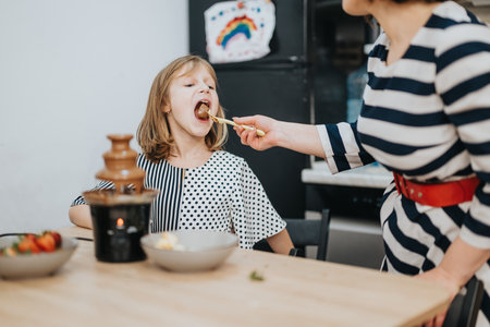 Happy mother and child enjoying a dessert together at homeの写真素材