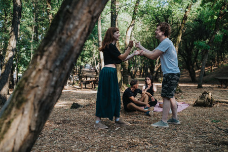 Friends enjoy a day outdoors in the forest park with a picnic and friendly exchangeの写真素材