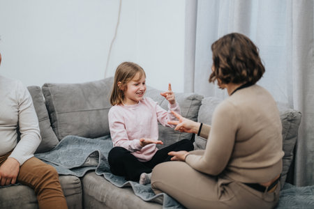 Family bonding through sign language communication on a cozy sofaの写真素材