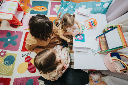 Cozy family art activity time with mother and daughters creating designsの写真素材