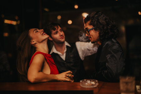 Laughing woman in red dress with friends at a stylish bar during a night out
