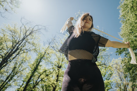 Woman exercising outdoors on a sunny day surrounded by greenery for weight cutting