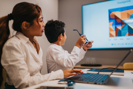 Family teamwork in a modern office as a child presents with glasses during a presentationの写真素材
