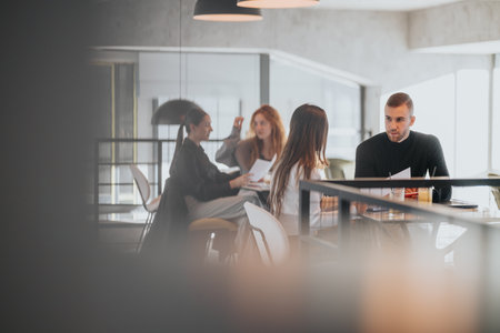 Team of colleagues in a modern office discussing documents during a business meetingの写真素材
