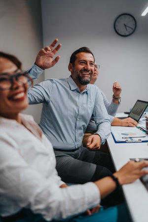 Team celebration in a modern office during a lively meeting with cheerful colleaguesの写真素材