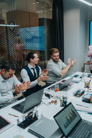 Group of professionals clapping and collaborating in a modern office during a business meeting