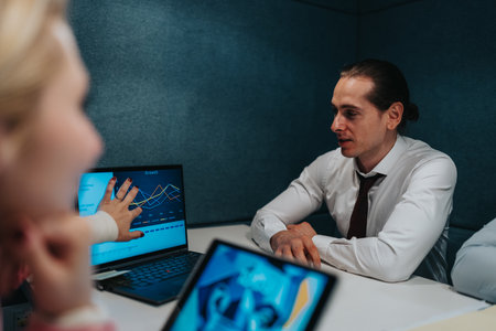 Business meeting with growth charts on laptop in a modern office settingの写真素材
