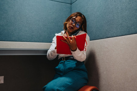 Professional woman in a modern office reads and takes notes while on a call