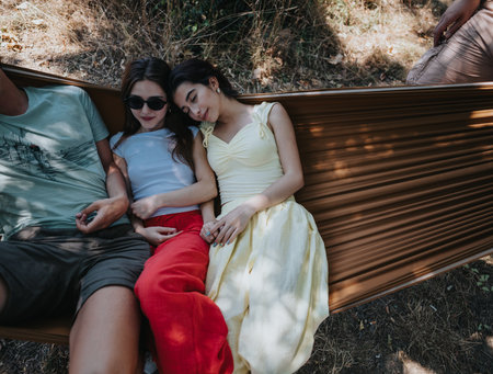 Friends relaxing in a hammock outdoors on a sunny summer dayの写真素材