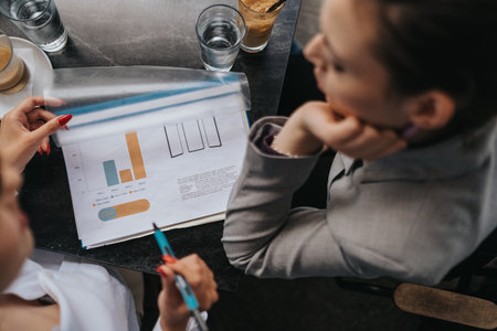 Business colleagues analyzing charts and discussing strategies during a meeting