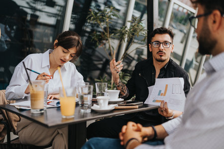 Young colleagues discussing ideas during a productive outdoor business meetingの写真素材