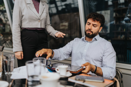 Male colleague contemplating while discussing documents at a business meetingの写真素材