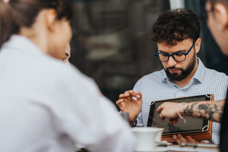 Team collaboration during a meeting using a tablet device in a workspaceの写真素材