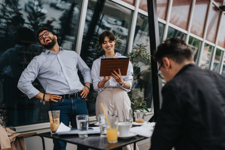 Group of co-workers laughing and collaborating outdoors during a meetingの写真素材