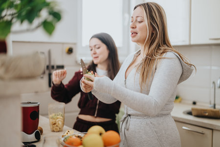 Two women preparing a healthy meal together in a cozy kitchenの写真素材