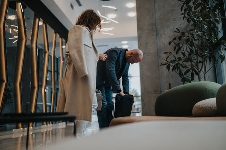 Business partners in a modern office lobby preparing for a meeting and travelの写真素材